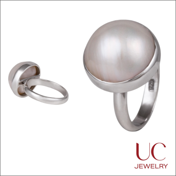 Discover the beauty of our Large Domed Pearl Ring. Crafted in high-shine .925 sterling silver, this statement ring showcases a stunning white shell cabochon. A perfect minimalist cocktail ring for those who love clean lines and high-quality craftsmanship.