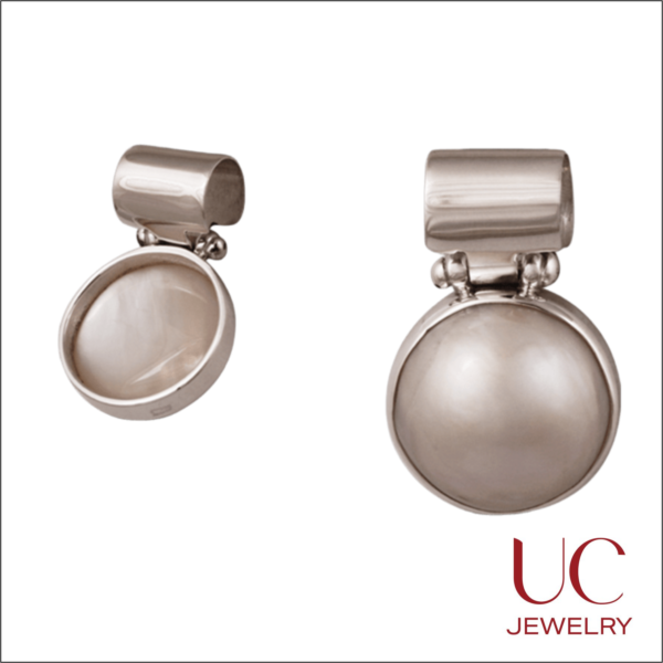 Shop UC Jewelry's Silver & Mother of Pearl Drops. Featuring a striking bezel-set cabochon and high-shine finish, these versatile earrings are the perfect gift for anniversaries, weddings, or June birthdays.